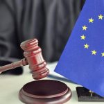 młotek sędziego i flaga unii europejskiej na biurku